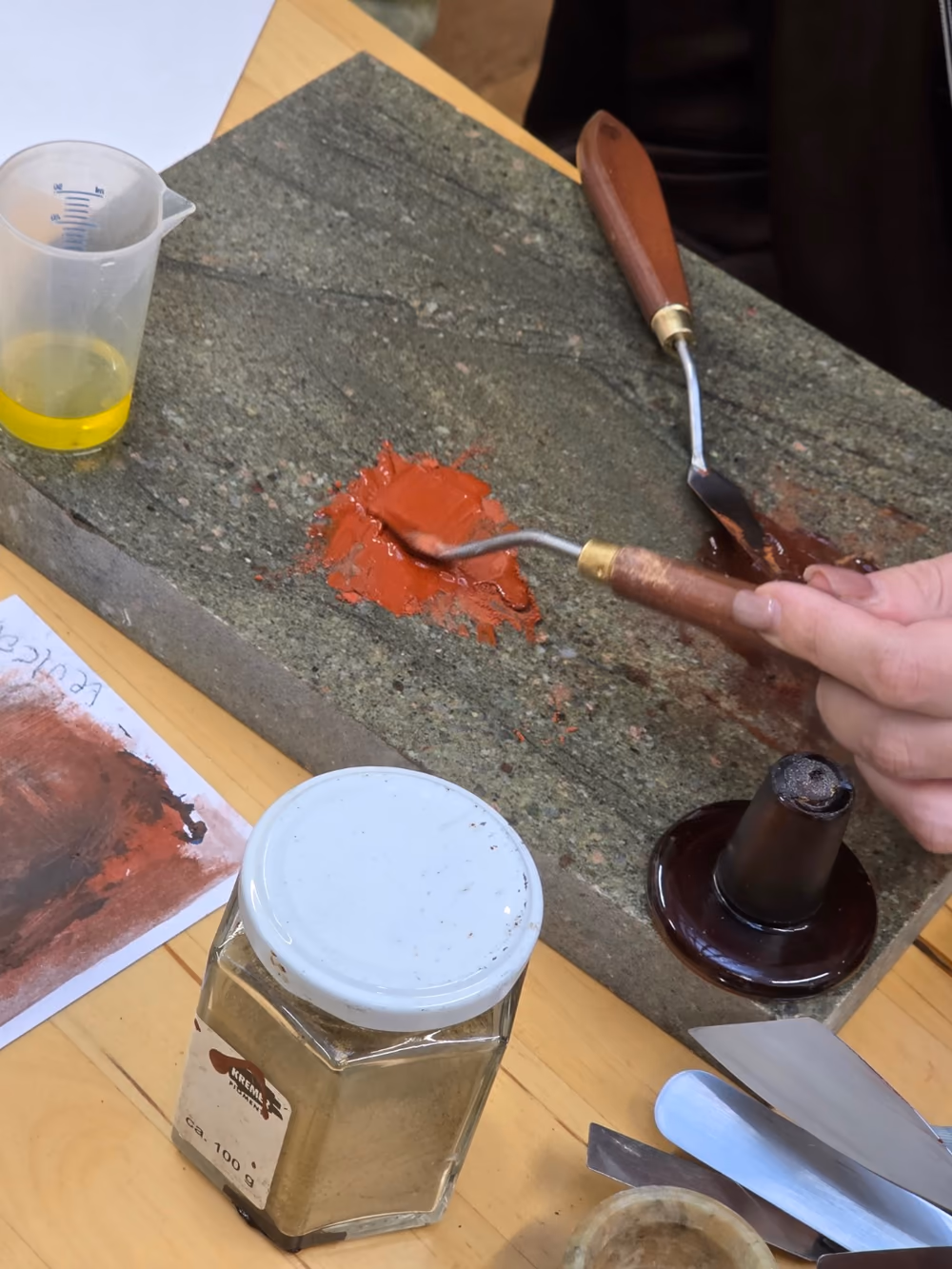 Pigment wird auf einer Steinplatte bearbeitet