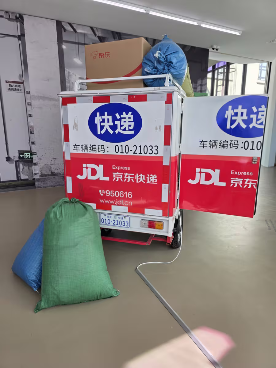 Gestapelte rote Versandkartons mit der Aufschrift DASH auf grünem Boden, Teil der Installation rund um Asia One.
