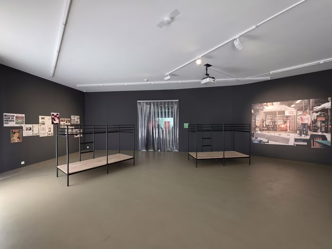 Zwei leere Stockbetten und eine freistehende Wand im Ausstellungsraum.